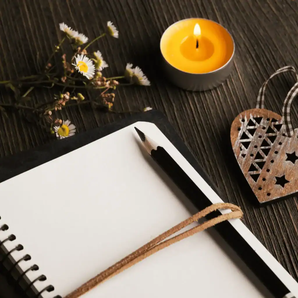 journal on table with tea light candle