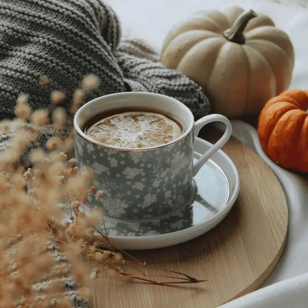 Tea with lemon and freshly harvested pumpkins on a table